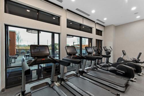 a gym with a row of tread machines and windows at Residence Inn by Marriott Atlanta Covington in Covington