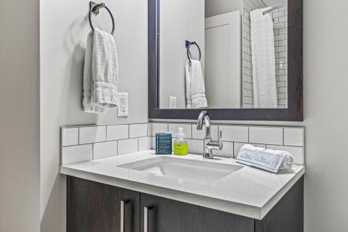 een badkamer met een wastafel en een spiegel bij Northwinds Hotel Canmore in Canmore
