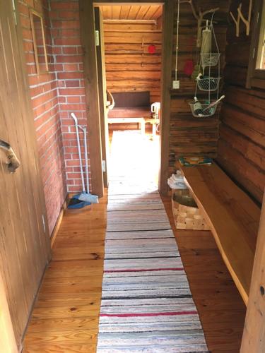 a hallway in a house with a rug on the floor at Valkolan kartanon saunatupa, yksi huone ja sauna in Hankasalmi