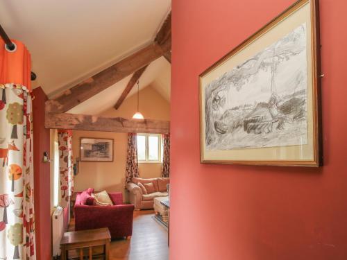 una sala de estar con paredes rojas y una pintura en la pared en The Flo Jo en Ellesmere