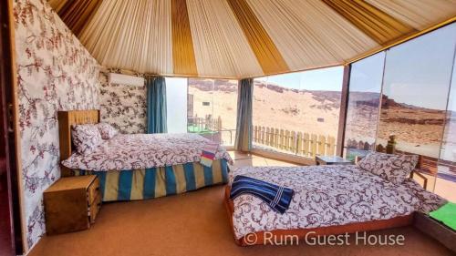 um quarto com duas camas e vista para o deserto em wadi rum guest house camp em Aqaba