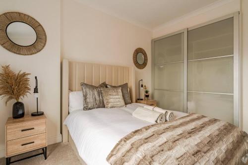a bedroom with a large bed and a mirror at Inicio Stays - Cosy Penthouse in the City Centre - Free Secure Parking - With City & Canal Views - Wrap Around Balcony - Netflix in Birmingham