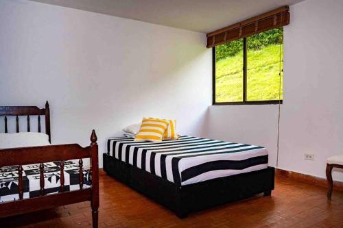 a bedroom with two beds and a window at Espectacular casa campestre in Pereira