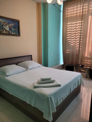 a bedroom with a bed with two towels on it at Star Hotel Didube in Tbilisi City