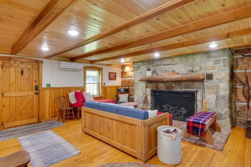 a living room with a stone fireplace in a cabin at Historic Morrisdale Area Cabin with Deck and Fireplace 