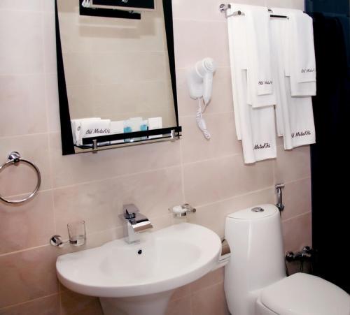 y baño con lavabo, aseo y espejo. en Old Metekhi Hotel, en Tiflis