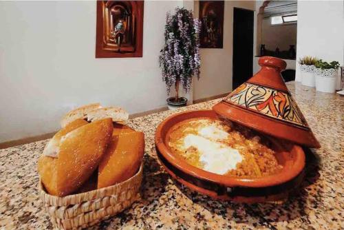 a counter top with bread and a dish of bread at Villa piscine Agadir in Agadir