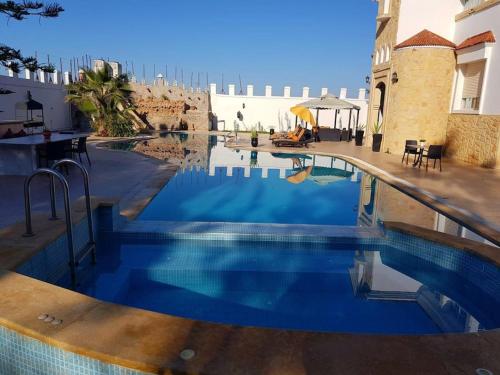 een zwembad met blauw water in een gebouw bij Villa piscine Agadir in Agadir