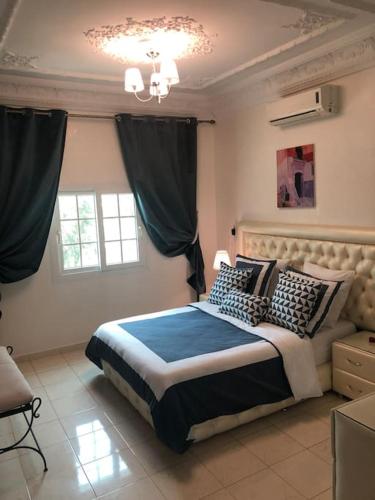 a bedroom with a large bed with black and white pillows at Villa piscine Agadir in Agadir