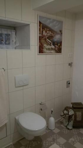 a bathroom with a toilet and a painting on the wall at 4 km zu A7 und A71, Idylle am Bach, großer Garten in Euerbach