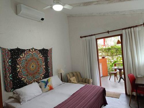 Un dormitorio con una cama con un tapiz en la pared. en CasAmar Pé na Areia em Condomínio Beira Mar, en Serra Grande