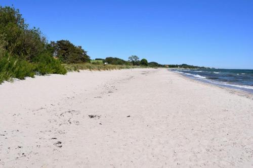 an empty beach with footprints in the sand at Mysigt hus i liten by nära havet in Ystad