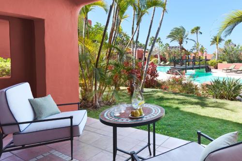 a patio with a table and chairs and a pool at The Ritz-Carlton Tenerife, Abama in Guía de Isora