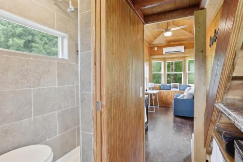 a bathroom with a shower and a toilet in a room at Pendergrass Tiny Home Cabin on Pond with Fire Pit! in Braselton