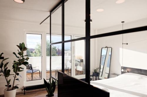 ein Schlafzimmer mit weißen Wänden und einem großen Fenster in der Unterkunft Apartman Aper in Znojmo