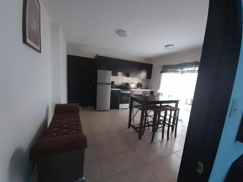 a kitchen with a table and chairs in a room at Departamentos velasco in Tijuana