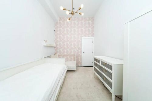 ein Schlafzimmer mit weißen Möbeln und einer rosa Wand in der Unterkunft Furnished and Meticulously Renovated 3-bedroom, 2-bathroom Loft in New York