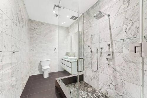a bathroom with a shower and a toilet and a sink at Furnished and Meticulously Renovated 3-bedroom, 2-bathroom Loft in New York