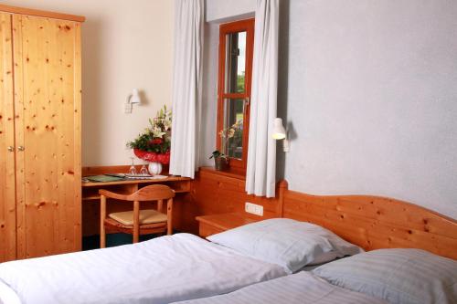 1 dormitorio con 2 camas y escritorio con ventana en Hotel & Gasthof zum Rödelseer Schwan, en Rödelsee