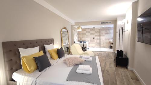 a bedroom with a large bed with yellow and black pillows at Instant Plaisirs - T2 60m2 avec Terrasse et Balnéo privative in Roquefort-la-Bédoule