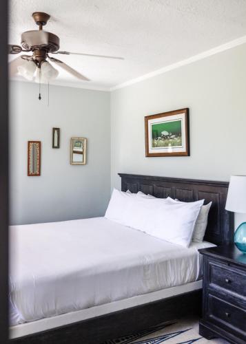 a bedroom with a white bed and a ceiling fan at Princess Anne Boutique Hotel in Asheville