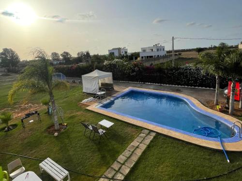 an image of a swimming pool in a yard at Villa avec Piscine, Terrain de Foot et Aire de Jeux pour Enfants in Bir Jedíd Saint-Hubert