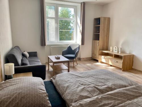 1 dormitorio con 1 cama, 1 sofá y 1 silla en Apartmány Havířská Žacléř, Krkonoše en Žacléř