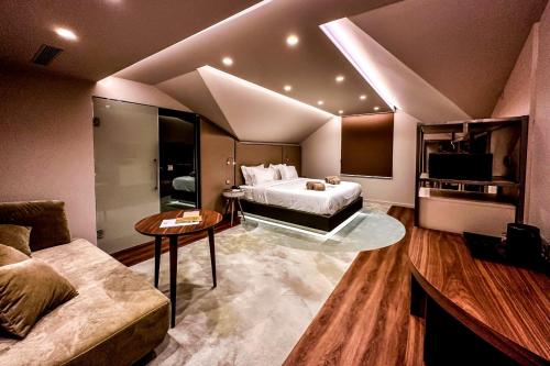 um quarto de hotel com uma cama e um sofá em Grande Hotel Thermas Nature & SPA em Termas de São Pedro do Sul