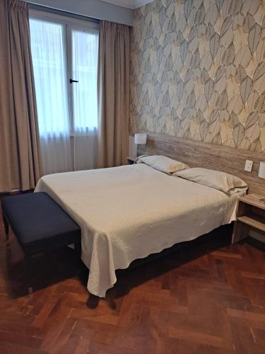 a bedroom with a large bed and a window at HOTEL REGIS in Buenos Aires