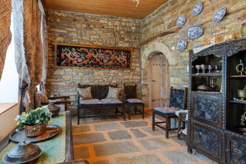 a living room filled with furniture and a stone wall at Monodendri Vintage House in Monodendri