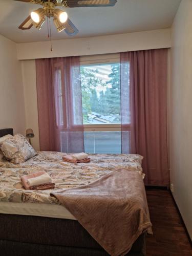 a bedroom with a large bed with a window at Viihtyisä saunallinen kaksio lentokentän lähellä in Vantaa