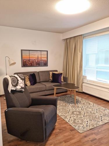 a living room with a couch and a table at Viihtyisä saunallinen kaksio lentokentän lähellä in Vantaa