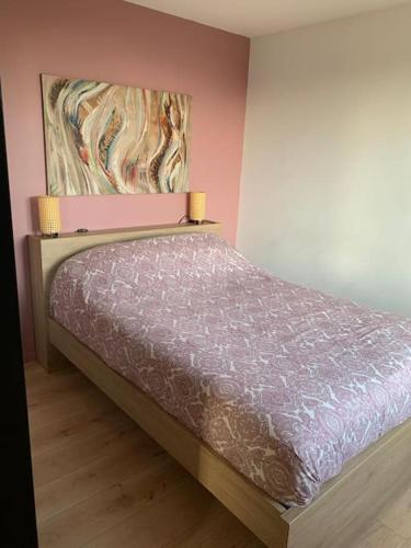 une chambre avec un lit avec un tableau sur le mur dans l'établissement Gîte de France Chez Fati, à Les Brunels