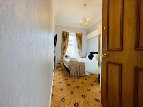 a hotel room with a bed and a window at Abbotsford Guest House in Edinburgh