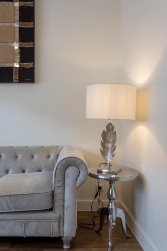 a living room with a couch and a table with a lamp at Apart Infante Casco Histórico de Ribadesella VUT-1322-AS in Ribadesella