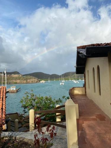 a rainbow in the sky over a body of water at Secret Harbour Boutique Hotel and Marina in Lance aux Épines