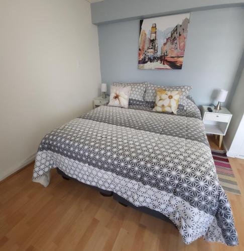 a bedroom with a bed with a black and white comforter at Departamento con Vista al Mar in Viña del Mar