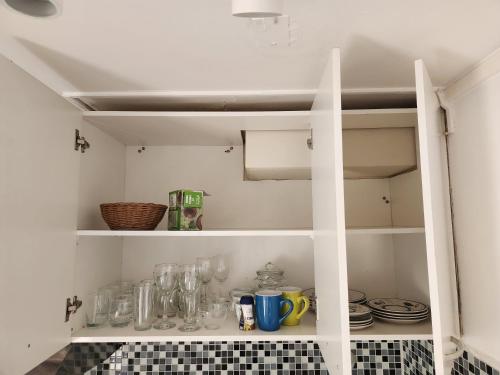 a cupboard filled with glasses and dishes in a kitchen at Departamento con Vista al Mar in Viña del Mar