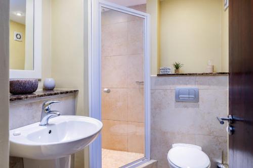 a bathroom with a shower and a sink and a toilet at Mystique 4 in Shelly Beach