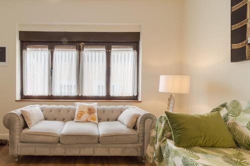 a living room with a couch and a window at Apart Infante Casco Histórico de Ribadesella VUT-1322-AS in Ribadesella
