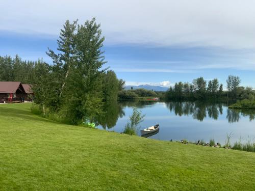 a boat on a lake next to a grass field at SkyWater Cabins in Hamilton