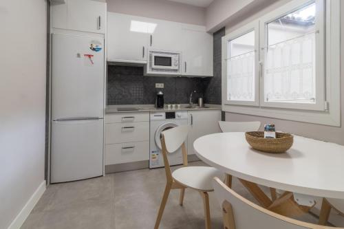 a kitchen with a white refrigerator and a table at Apart Infante Casco Histórico de Ribadesella VUT-1322-AS in Ribadesella