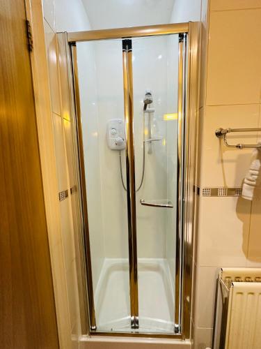 a shower with a glass door in a bathroom at Abbotsford Guest House in Edinburgh