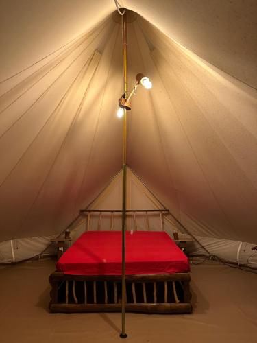 Posto letto in tenda con lenzuolo rosso di Il Favogoloso ad Alatri