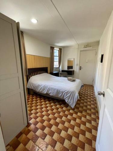 1 dormitorio con 1 cama y suelo de madera en 1D CLOSe en Nueva York