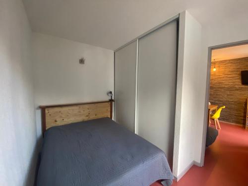 1 dormitorio con 1 cama y puerta corredera en Appartement idéalement situé wifi disponible, en Cauterets