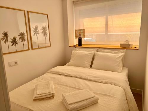 - une chambre avec un lit et des serviettes dans l'établissement Sweet Sandy Beach - 1 minute walk to Mediterranean beaches, à Santa Pola