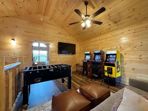 a room with a ping pong table and arcade games at Wildwood Retreat Indoor Pool Hot Tub Game Area in Pigeon Forge