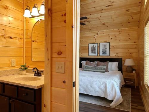 a bedroom with a bed and a sink in a room at Wildwood Retreat Indoor Pool Hot Tub Game Area in Pigeon Forge