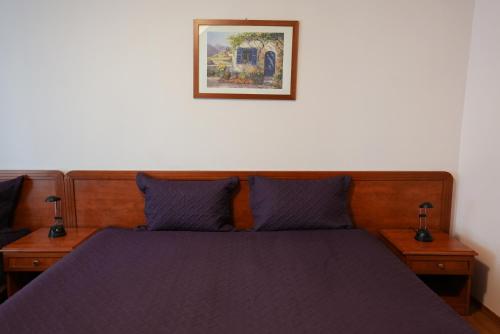 a bedroom with a purple bed with two night stands at Hotel Gold Inn in Peje